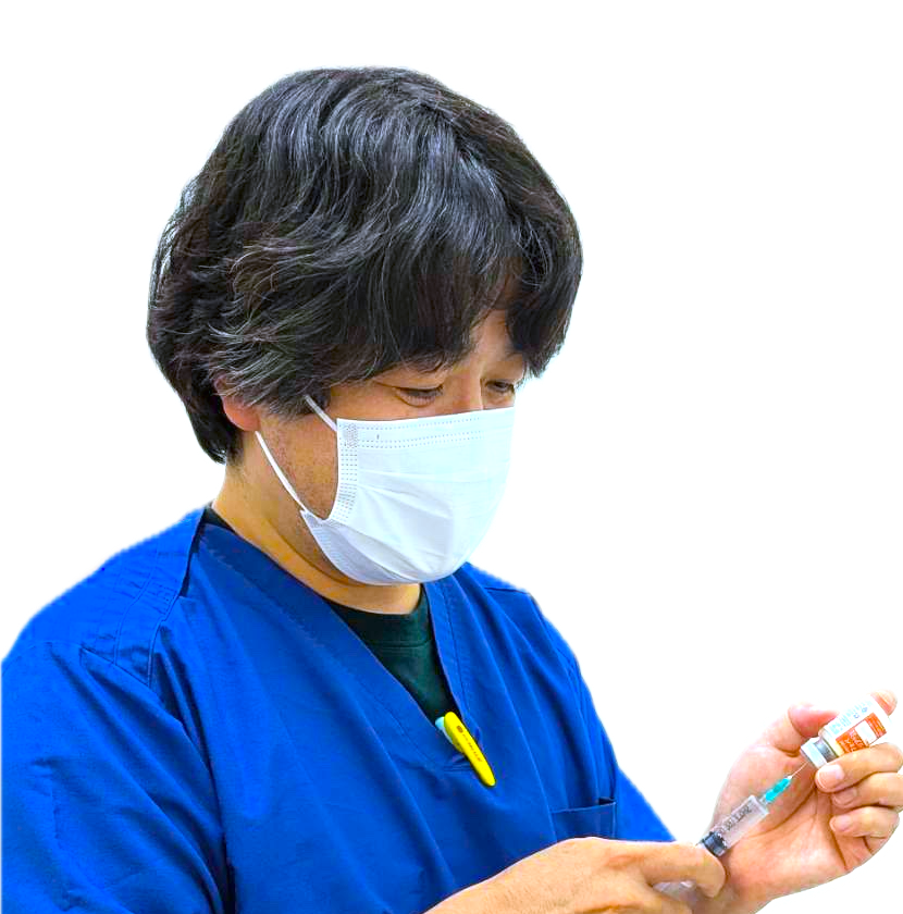 男性獣医師_青い上着を着て_注射の準備をしている